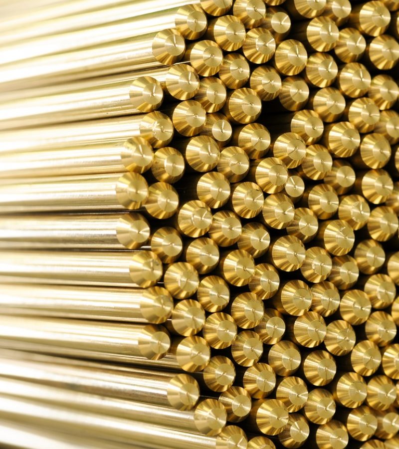 Close up on ends of newly manufactured long brass rods in a bundle for industry concept